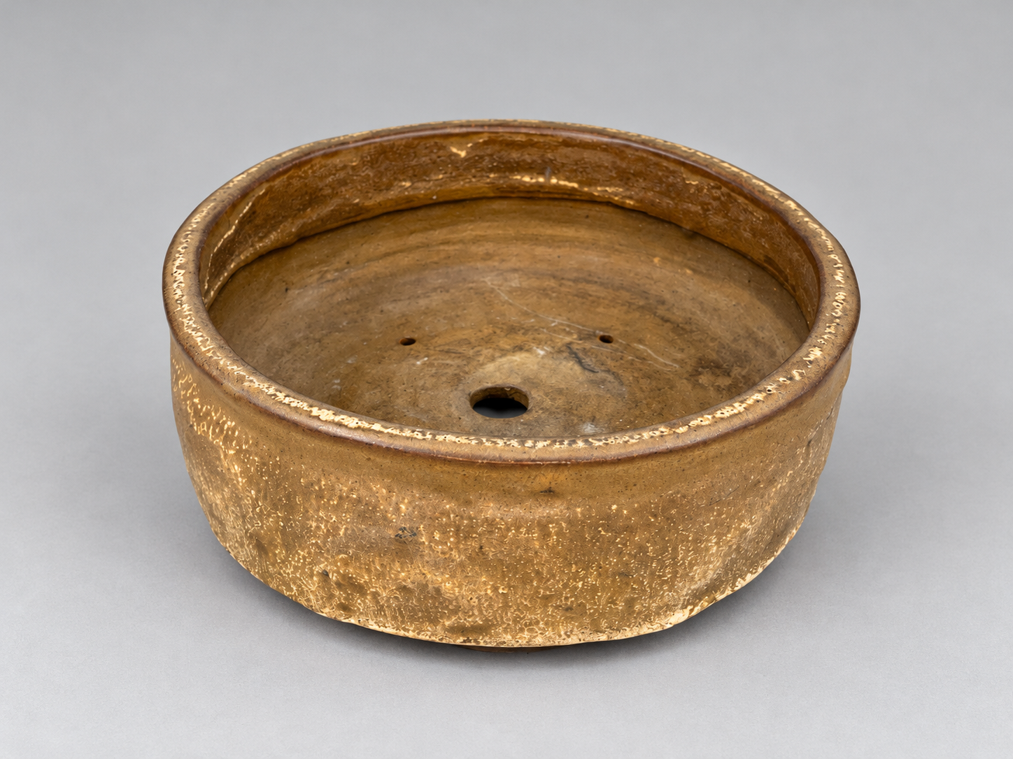 Round bronze-brown glazed pot with a deep low profile and drainage holes